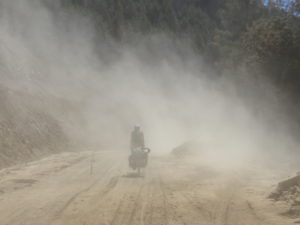 China, Ost Tibet, Bettina wird von der Staubwolke eines LKWs verschluckt